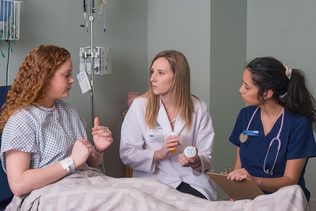 A nursing student and a pharmacy student practicing speaking with a patient