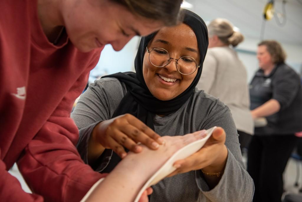 An Occupational Studies student practices applying a splint on a classmate's wrist