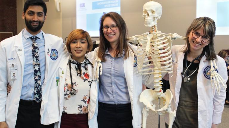 四个英国东北大学骨科医学院的学生摆出一副教育骨架的姿势