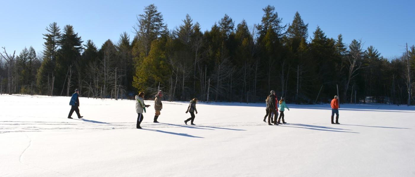 U N E students explore a snowy field