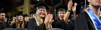 两位毕业生在大学毕业典礼上鼓掌欢呼 