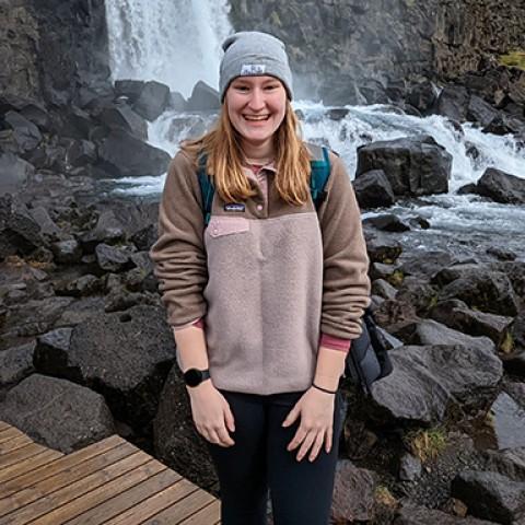 U N E student Megan Hanks stands in front of a waterfall